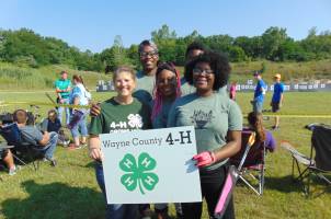 4-H youth holding Wayne County 4-H sign.