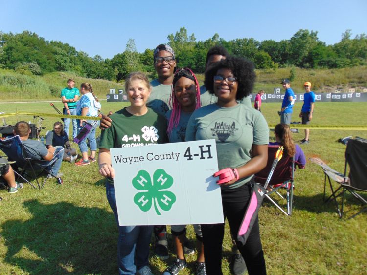 4-H youth holding Wayne County 4-H sign.