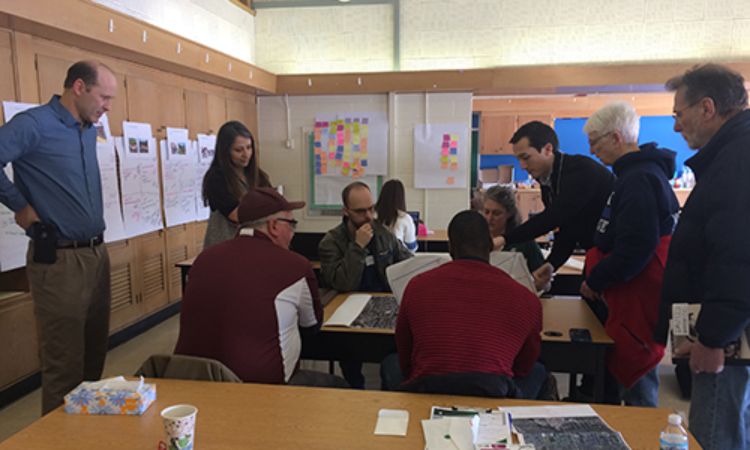 Image of residents, representatives from neighborhood organizations, City staff, and the NCI design team talking through potential design solutions in the neighborhood during the charrette.