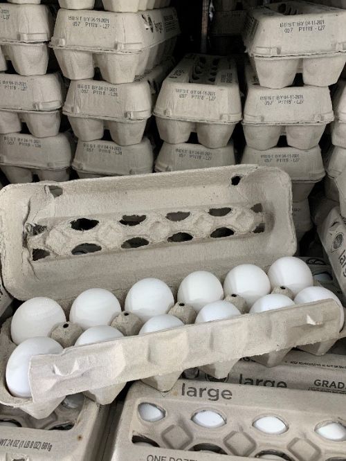 Several cartons of eggs stacked on top of each other.