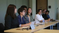 Students sit at table.