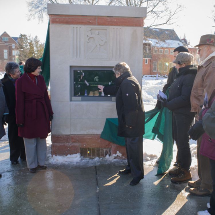 MSU President Lou Anna K. Simon demonstrates how to use one of the new touchshcreen kiosks at the Morrill Plaza.