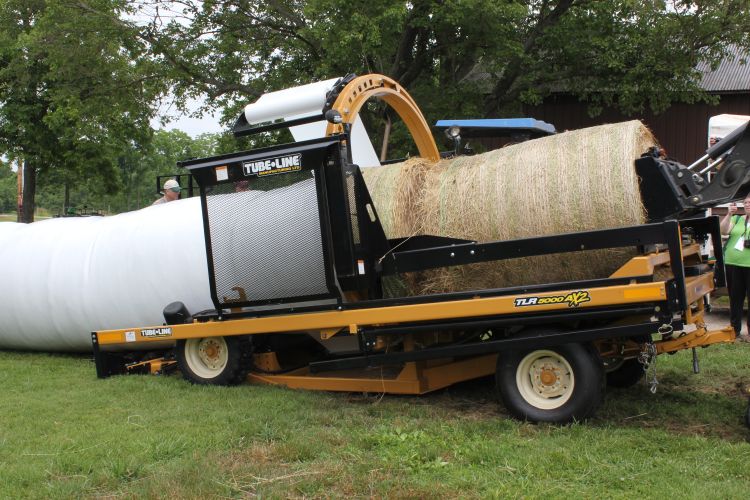 Round bales of hay being wrapped.