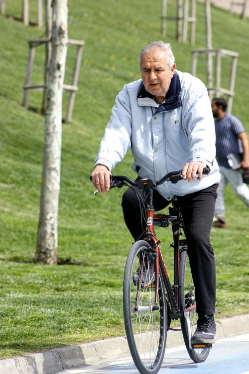 An older adult riding a bike.