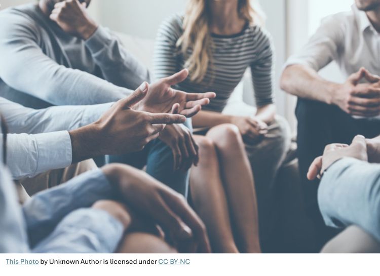 A group of people sitting around in a circle.