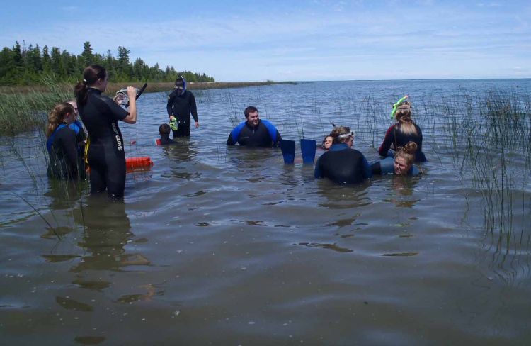 Campers with Travis Wahl in Lake Huron getting ready to swim to the Albany.