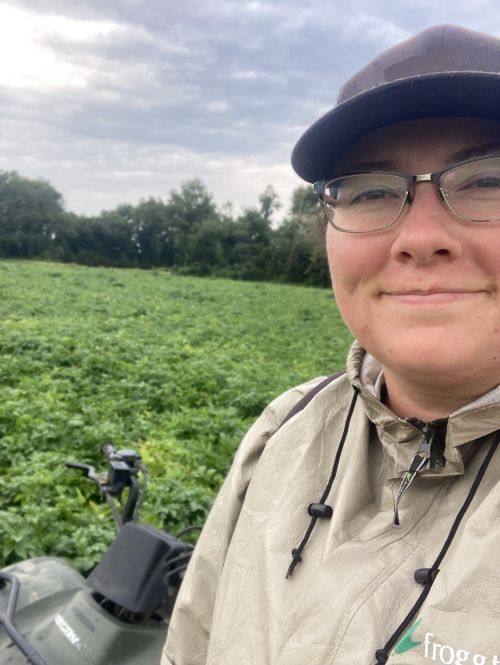 Nicolle Ritchie stands in a field smiling.