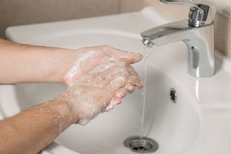 A person washing their hands.