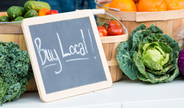 Fresh produce sits on a table next to a chalkboard sign that has 