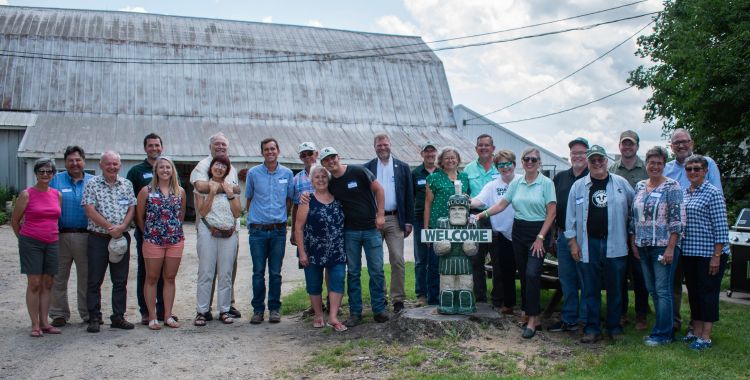 MSU and state leaders gather with staff from Great Lakes Sire Service and Preston Farms around a Sparty statue on Preston Farms in Quincy, Michigan.