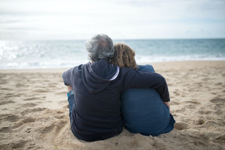 Older couple sitting on a beach.