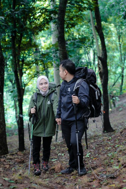 A photo of two people hiking in the woods with backpacks on.