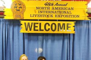 Three young adults posing for a photo together at the North American International Livestock Exposition.