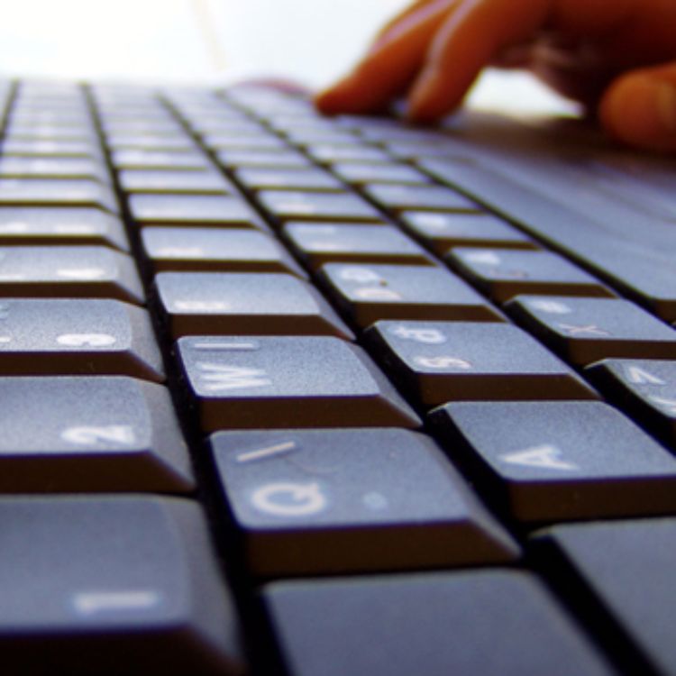 Person typing on computer keyboard.