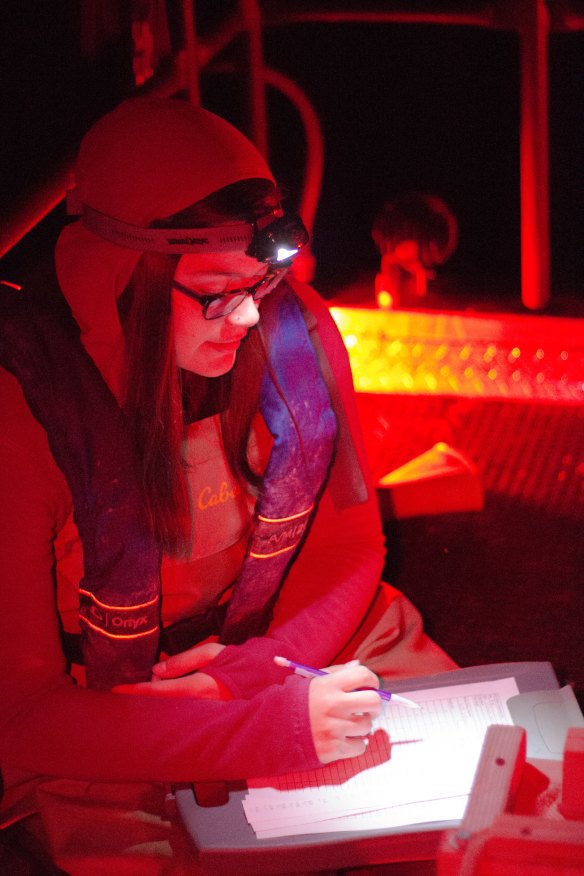 Woman in fishing boat recording data