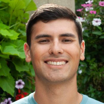 Christian Terwillegar Smiling headshot with Horticultural Gardens Backdrop, Flowers