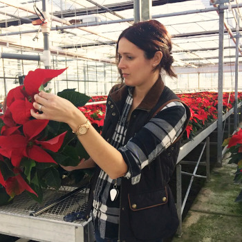 Sarah Jandricic holding flowers in a greenhouse.