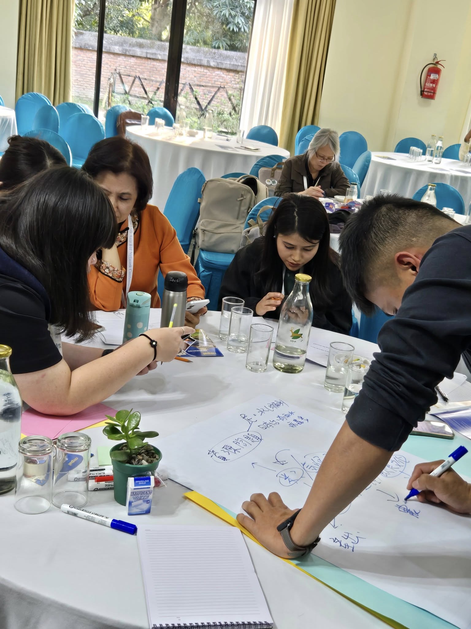 Un grupo de personas alrededor de una mesa trabajando.