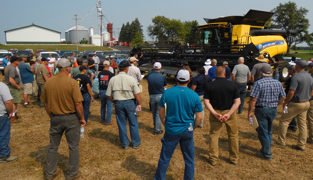 A group of people who are gathered for the soybean harvest field day