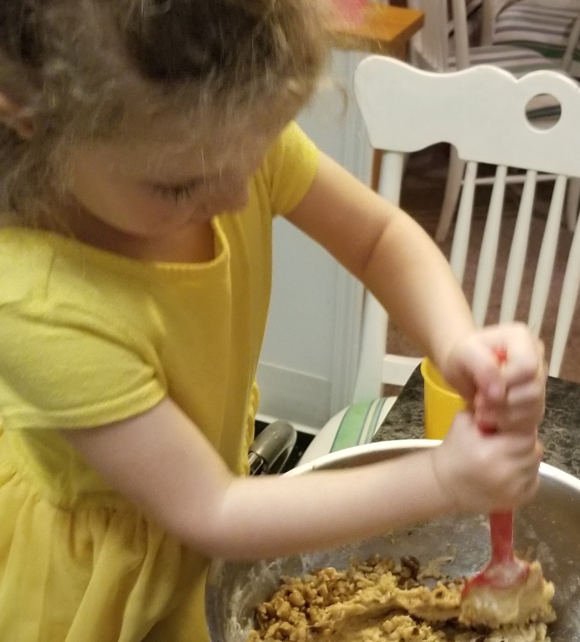 Young child mixing a bowl of cookie dough