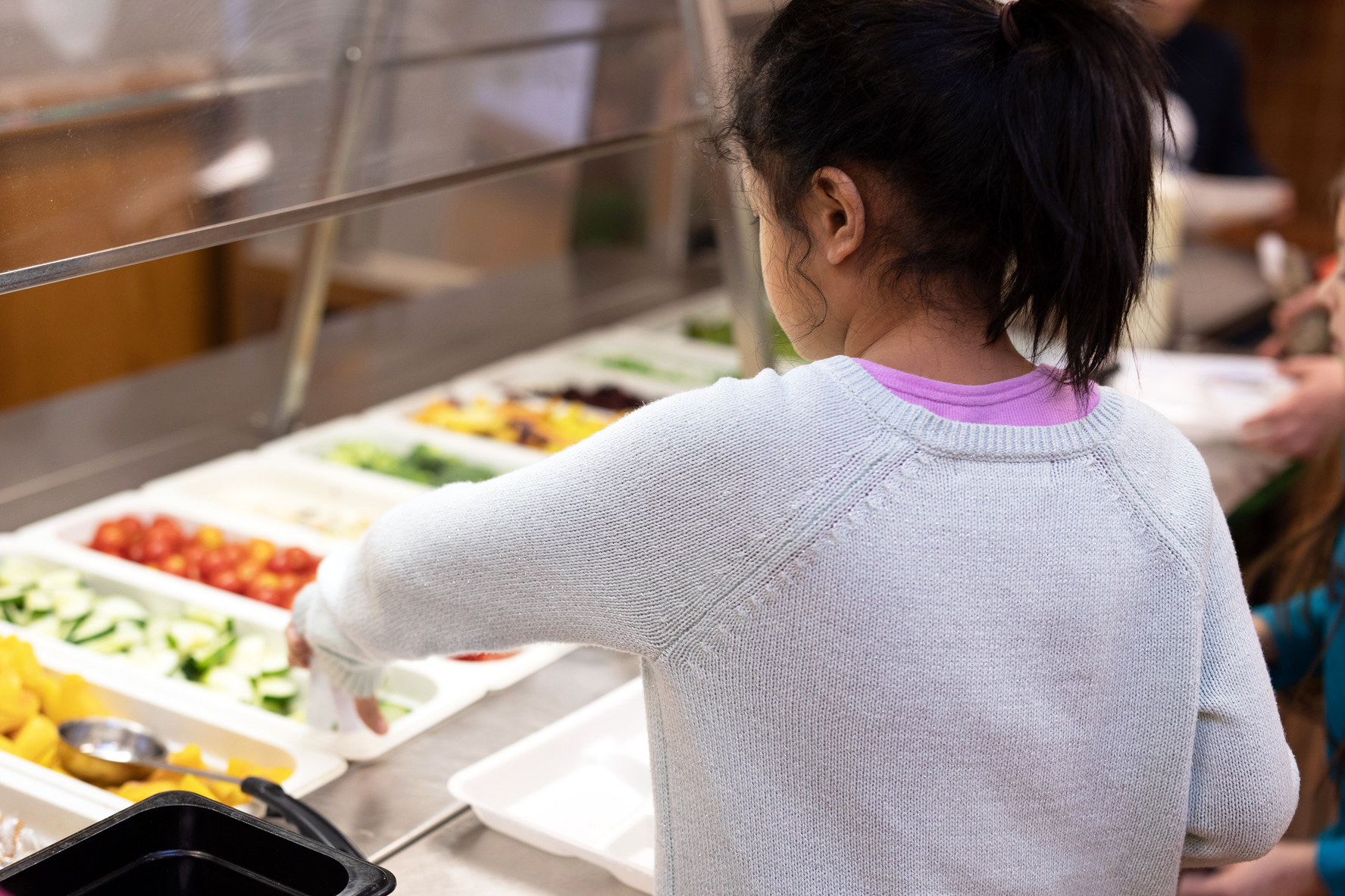 Student selects Michigan-grown fruits and vegetables during school lunch