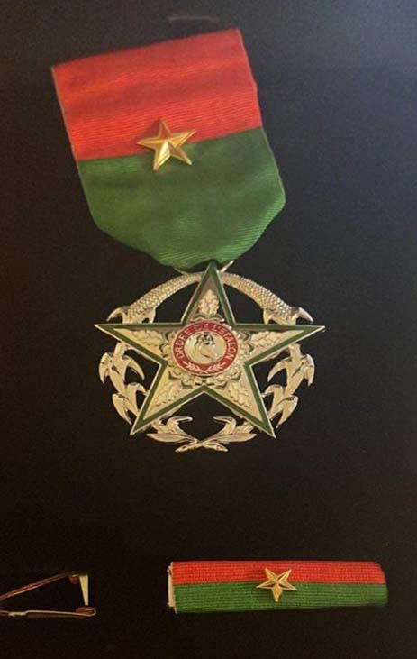 Star shaped medal with a red ribbon on black velvet