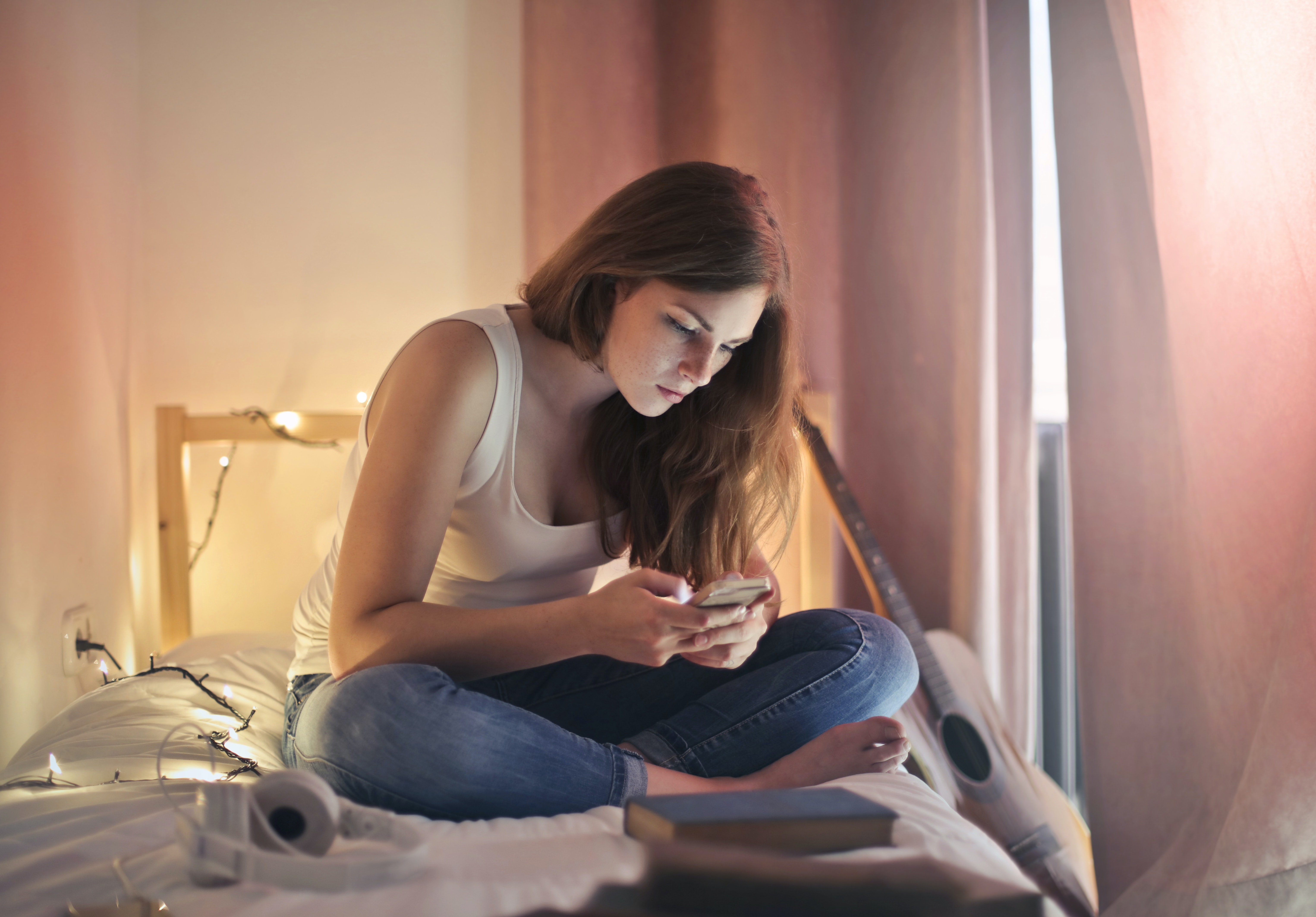Woman scrolling on phone in bed