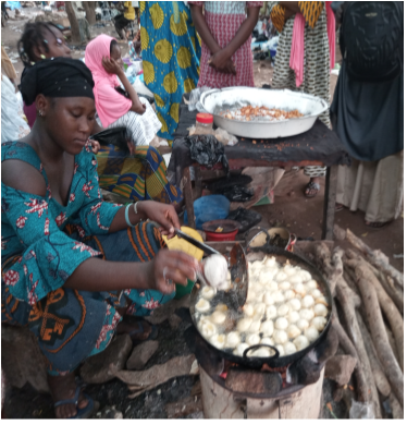 Figure 2. Malian woman selling cowpea doughnuts in a market. Credit. Mamadou Sissoko (2020)