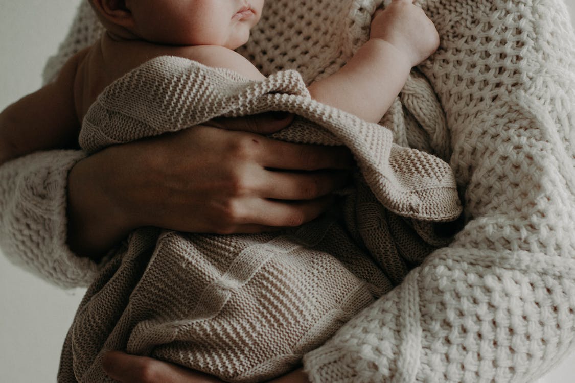 A mother holding a small infant.