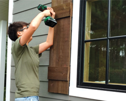 Hanbing Liang installing shutter on Sparty's Cabin.