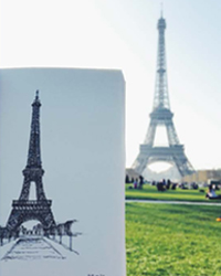 Drawing held up against the Eiffel Tower in the distance in Paris, France.