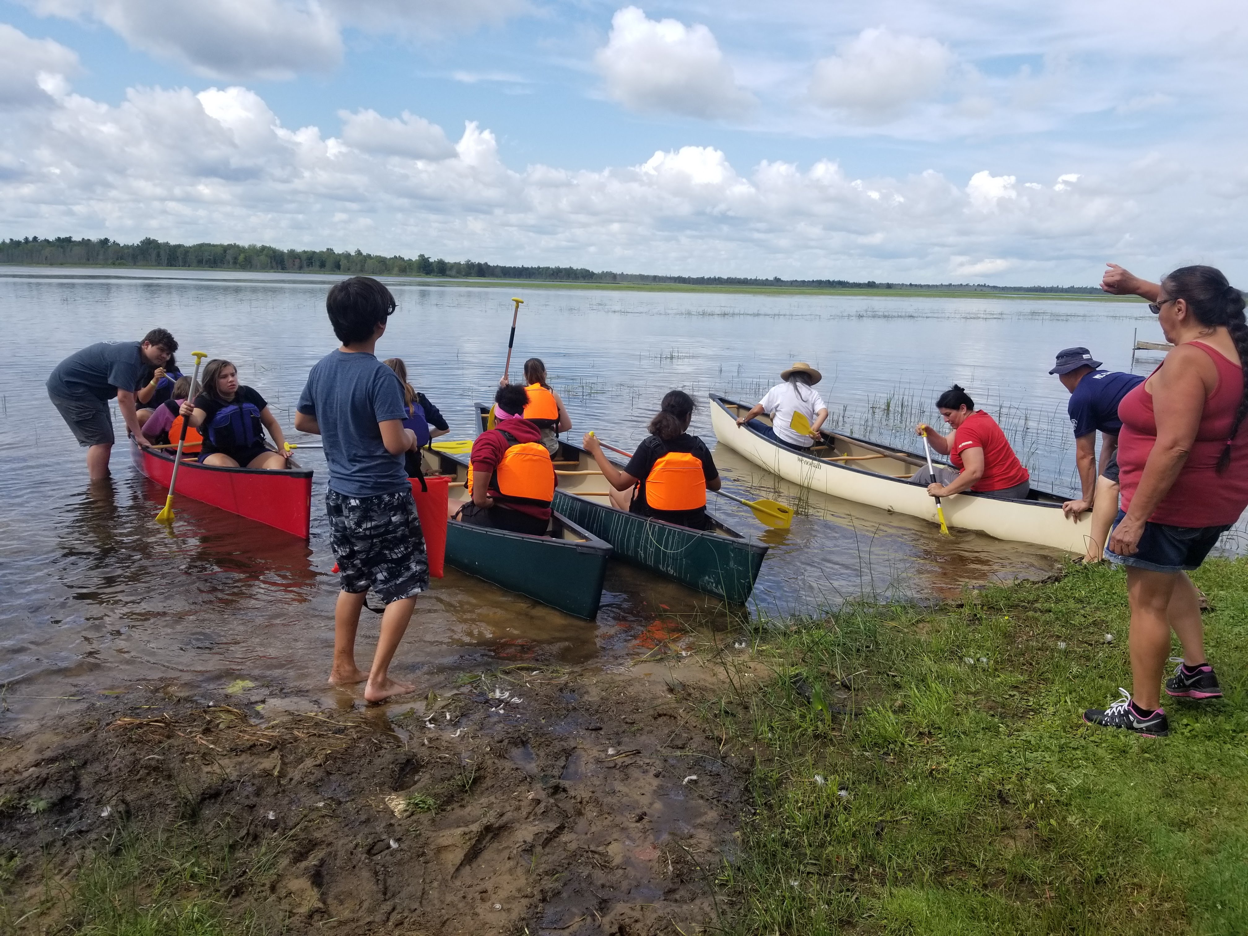 Youth paddle in canoes.