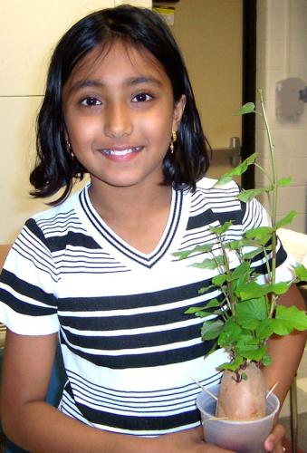 Girl holding plant.