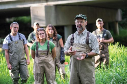 Dan Hayes teaches a fisheries class outdoors at MSU