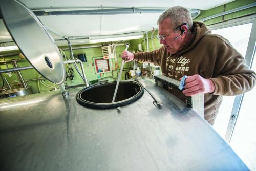 Bob Cooley, milk processor at the MSU dairy farm, takes a milk sample at the MSU milk parlor. All dairy farm milk is rigorously tested for antibiotic residues before shipment in an effort to ensure a secure dairy supply.