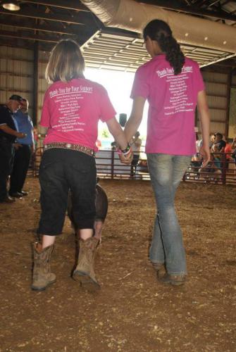 Two girls showing a hog