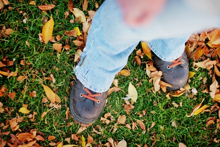 Boy standing in fall leaves. 