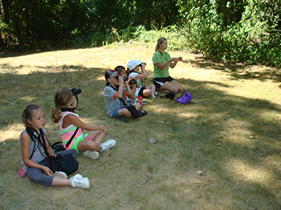 Youth birdwatchers sitting on grass