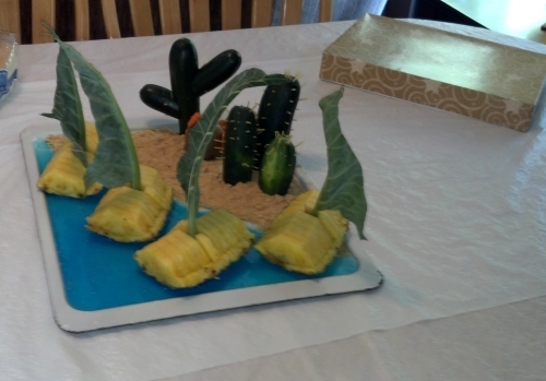 Zucchini and cucumber cactuses and pineapple boats picnic centerpiece.
