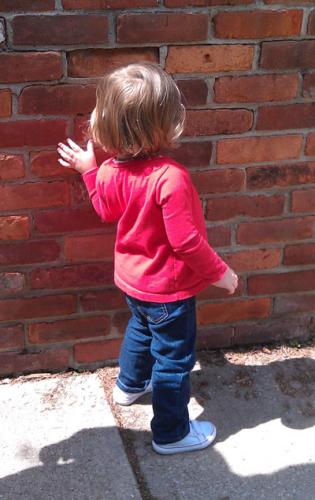 CHILD AT BRICK WALL