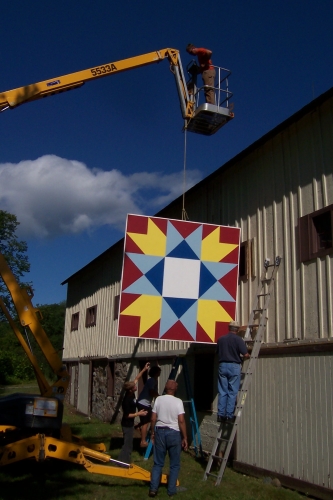 Hoisting quilt onto barn