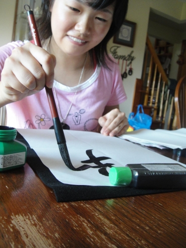 Japenese student displays her writing techniques and artistic abilities.