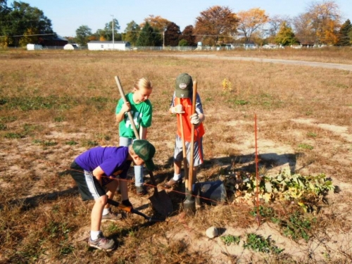 3 4-H members preparing to plant a tree