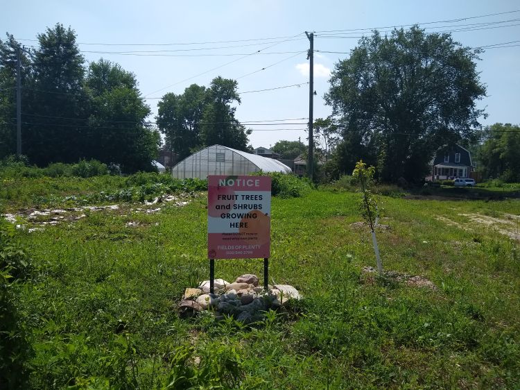 An urban farm with a sign out front that says 