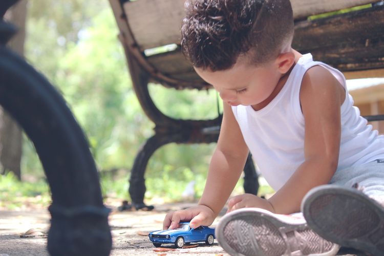 Little boy playing with toy car.