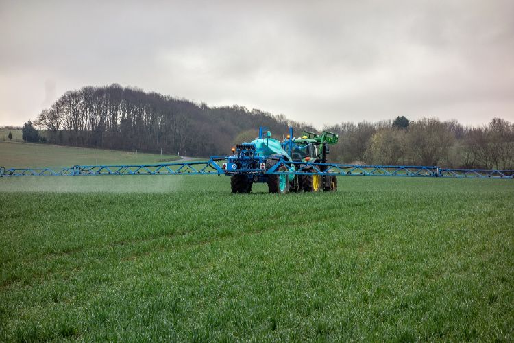 tractor spraying pesticide in a field