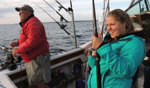 4-H girl fishing on charter boat with captain
